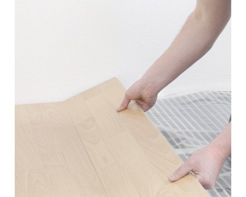 Eine Person verlegt Laminatboden.