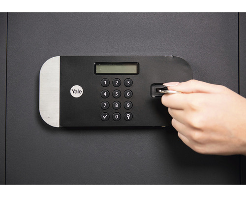 Ein Tresor mit einem digitalen Tastenfeld wird mit einem Schlüssel geöffnet. Yale Logo