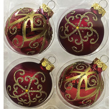 Vier Christbaumkugeln mit goldenen Verzierungen in einer Verpackung.