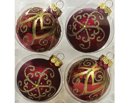 Vier Christbaumkugeln mit goldenen Verzierungen in einer Verpackung.