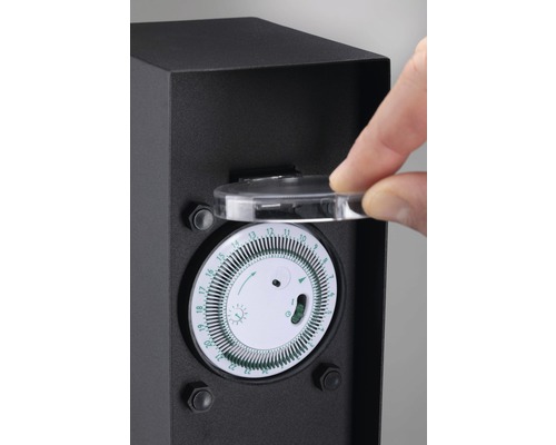 Zeitschaltuhr in einem schwarzen Gehäuse mit einer Hand, die den durchsichtigen Deckel öffnet.