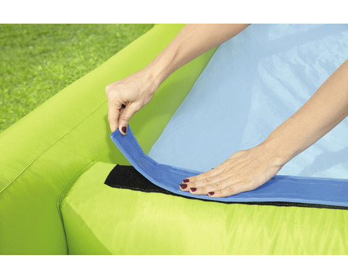 Detailaufnahme eines aufblasbaren Produkts mit einer Person, die eine blaue Lasche an einem grünen Stoff befestigt.