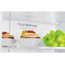 Innenansicht eines Kühlschranks mit der Aufschrift Total NoFrost und Energieeffizienzklasse A++, mit Gebäck und Weintrauben.