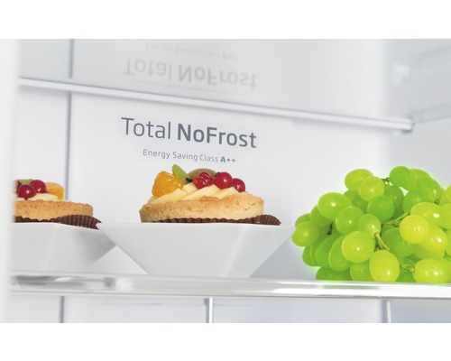 Innenansicht eines Kühlschranks mit der Aufschrift Total NoFrost und Energieeffizienzklasse A++, mit Gebäck und Weintrauben.