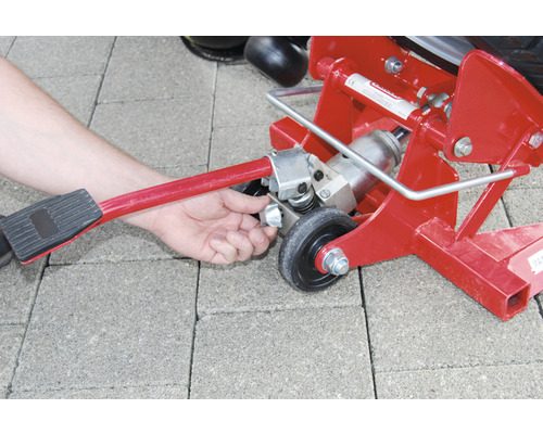 Roter Rangierwagenheber im Einsatz mit Hand