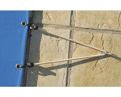 Detailaufnahme einer Poolabdeckung mit Befestigungsseil am Beckenrand