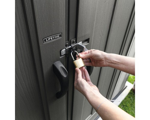 Person verschließt Geräteschuppen mit Vorhängeschloss