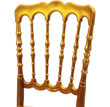 Detailansicht der Rückenlehne eines goldenen Bankettstuhls.