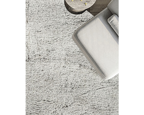 Detailansicht eines Wohnzimmers mit flauschigem Teppich, Sofa und kleinem Tisch