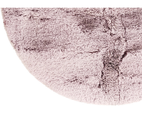 Detailansicht eines runden, zotteligen Teppichs