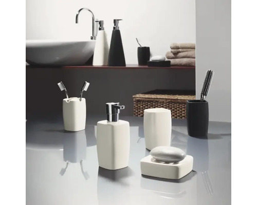 Badezimmer mit Waschbecken, Handtüchern und diversen Badaccessoires wie Seifenspender und Zahnbürstenhalter.