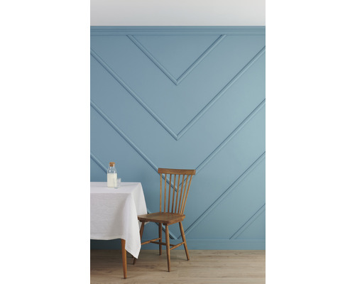 Helle Küche mit blau getäfelter Wand, Tisch und Holzstuhl.