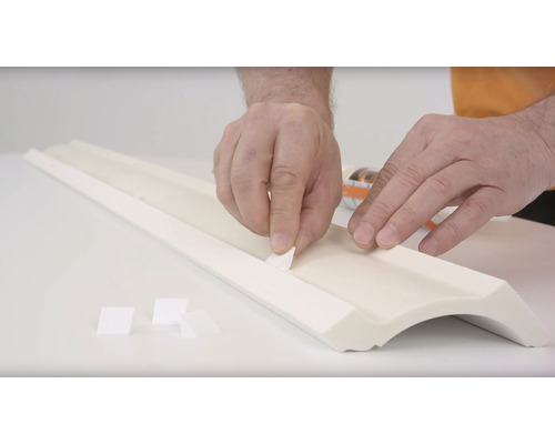 Anbringen von Montageklebeband an einer Zierleiste