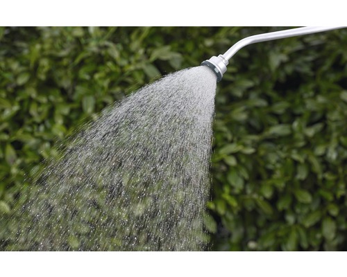 Gartendusche mit Wasserstrahl vor grünem Hintergrund