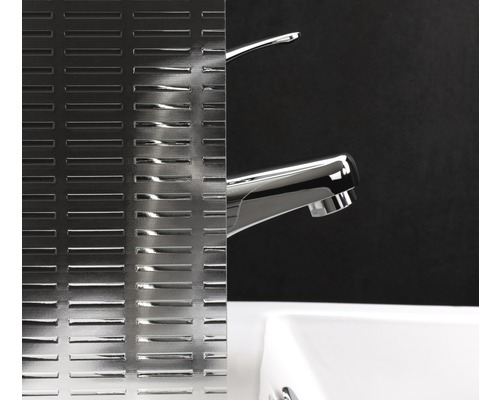 Dekorglas mit linearem Muster neben einem Waschbecken und einer Armatur