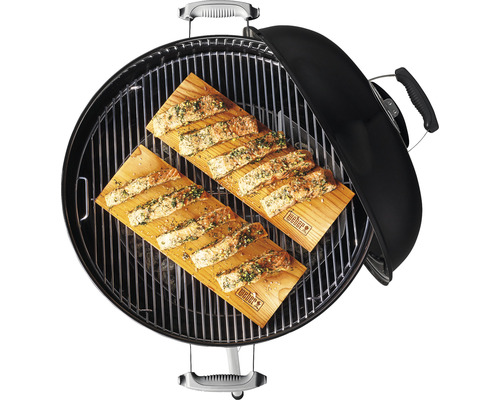 Grill mit zwei Holzbrettern und Lachs zum Grillen