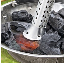 Grillanzünder mit glühenden Holzkohlebriketts in einem Holzkohlegrill