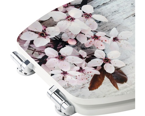 Toilettensitz mit Blütenmuster und verchromten Scharnieren