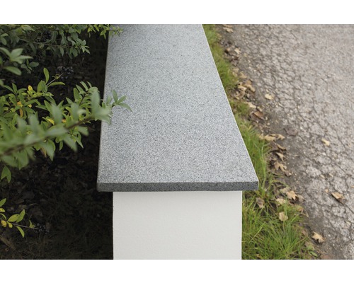 Detailansicht einer Mauerabdeckung aus Naturstein auf einer Mauer