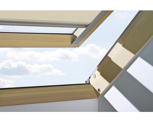 Geöffnetes Dachfenster mit Verdunkelungsrollo und Blick auf den Himmel