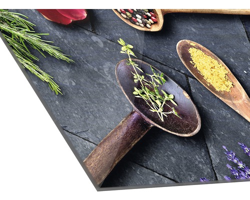 Dekoratives Küchenbild mit Kräutern und Gewürzen auf Löffeln