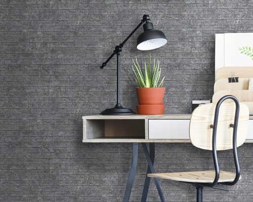 Wandgestaltung mit grauen Ziegelsteinen hinter einem Schreibtisch mit Lampe und Pflanze