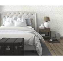 Schlafzimmer mit Bett, Nachttisch und dekorativer Truhe