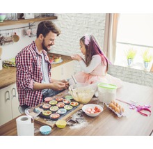Vater und Tochter backen gemeinsam Muffins in der Küche.