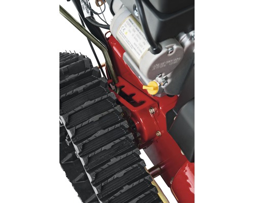 Detailansicht einer Schneefräse mit Kettenantrieb und Motor