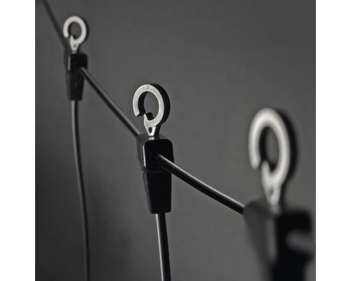 Detailaufnahme einer Lichterkette mit Halteclips und Haken zur Befestigung