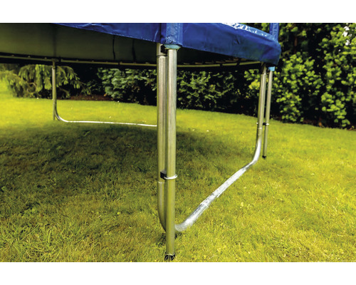 Detailansicht eines Gartentrampolins mit Stahlrahmen und blauer Randabdeckung auf einer Rasenfläche
