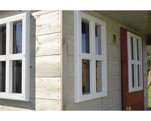 Detailansicht eines Spielhauses mit Holzverkleidung und weißen Fensterrahmen.