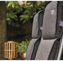 Nahaufnahme von grauen Gartenmöbelkissen mit Pflanzen im Hintergrund