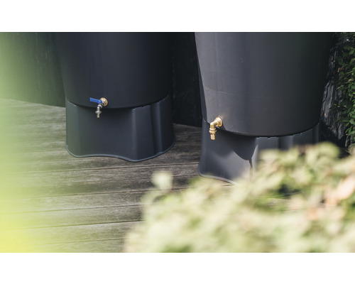 Nahaufnahme von zwei Regentonnen mit Wasserhahn auf einer Holzterrasse