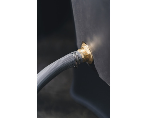 Detailaufnahme eines Wasserbehälters mit angeschlossenem Gartenschlauch