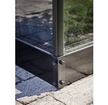 Detailaufnahme eines Glaszauns mit Metalleckverbindungen auf Pflastersteinen