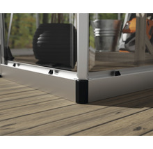 Detailansicht eines Gewächshauses auf einem Holzdeck mit Metallrahmen und Glaseinsätzen.