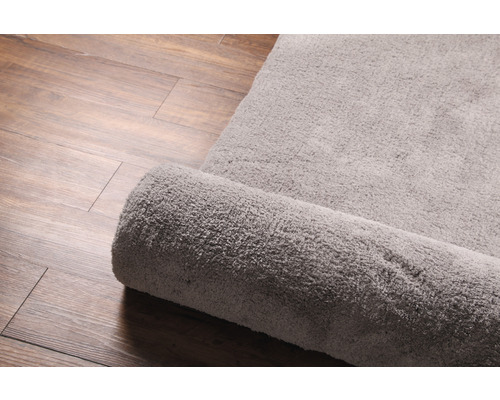 Teppich aus Stoff, teilweise aufgerollt, auf Holzboden