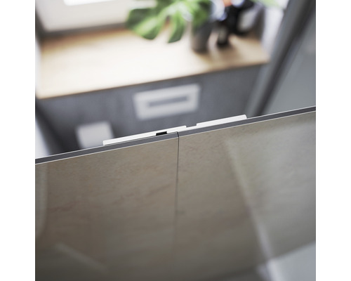 Detailaufnahme einer Duschkabine mit Fliesen und Beschlägen in einem Badezimmer.