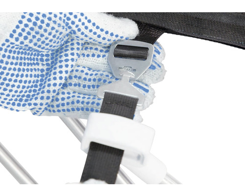 Detailaufnahme einer Hand mit Arbeitshandschuh, die einen Verschluss an einem Spanngurt befestigt.