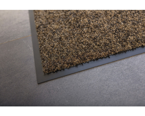 Detailansicht einer braunen Schmutzfangmatte mit einem schwarzen Rand.