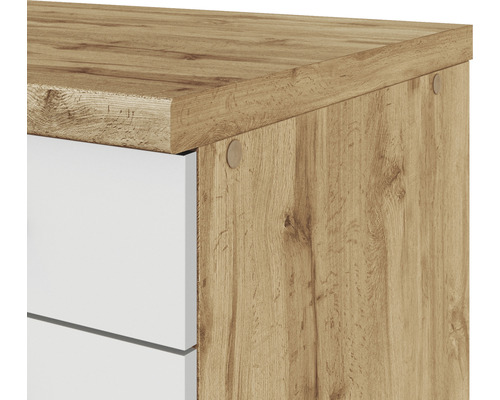 Detailaufnahme eines Schranks mit Holzmuster und weißen Schubladen