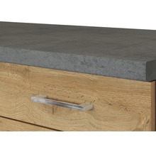 Detailaufnahme eines Möbels mit grauer Oberfläche und Holzschublade mit Griff