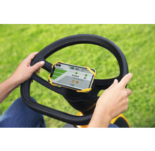 Person bedient Rasentraktor mit Smartphone-Halterung am Lenkrad