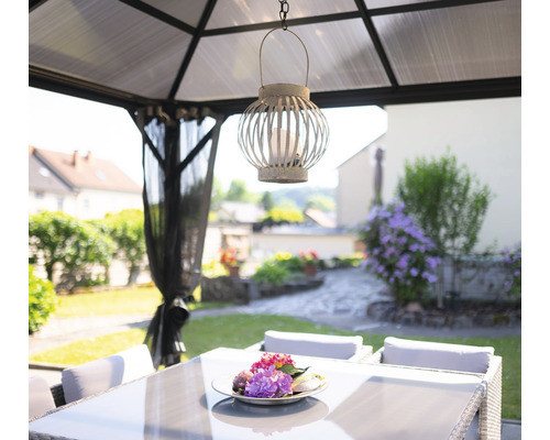 Gartenpavillon mit Esstisch und dekorativer Laterne