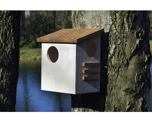 Vogelhaus aus Holz mit zwei runden Eingängen am Baum