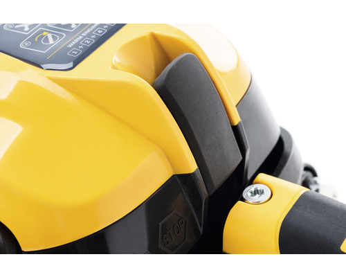 Detailansicht eines gelben Motorkappenteils mit Schalter und Stoppschild