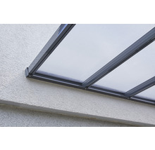 Nahaufnahme einer Terrassenüberdachung mit transparenten Paneelen und Rahmen an einer Wand.