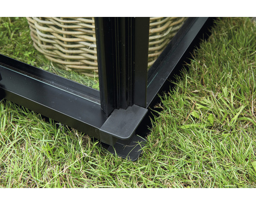 Detailansicht eines Gewächshausrahmens aus Metall mit Glas und Kunststofffuß auf Gras