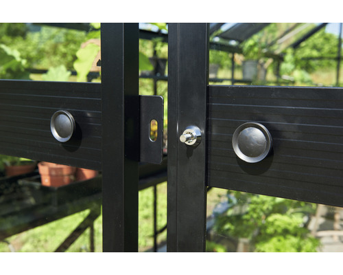 Detailansicht eines Gewächshausfensters mit Griff und Schloss